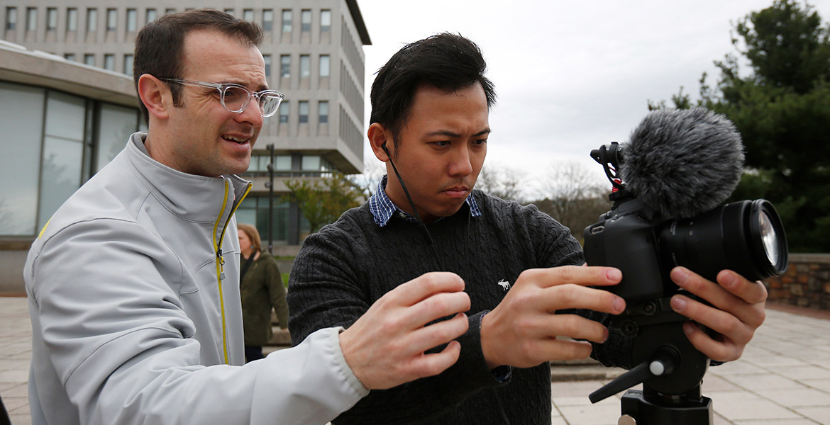 Matt Veto, professor of practice in journalism and communication and faculty adviser to The Brown and White, helping a student with a video camera