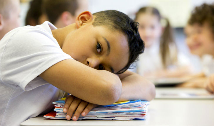 Student with head resting on desk