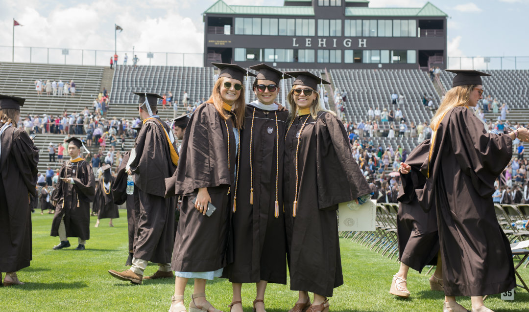 Three female graduates at Lehigh University commencement