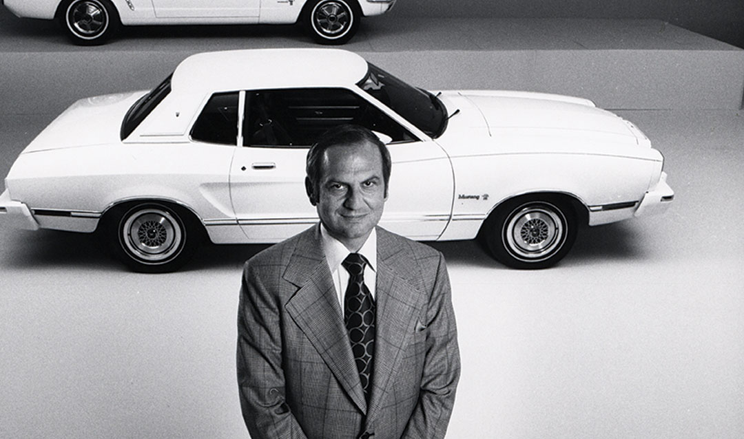 Lee Iacocca stands in front of Mustang