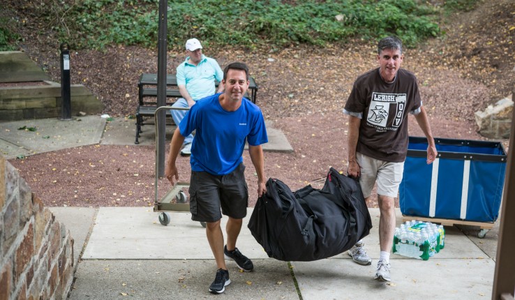 Lehigh Provost Patrick Farrell carries student belongings during move-in day