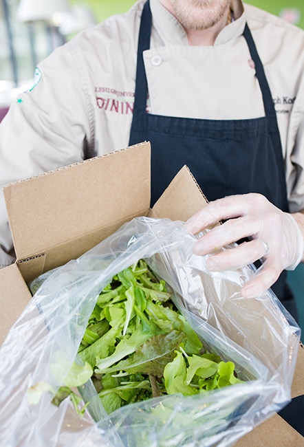 Dining staff with a box of lettuce