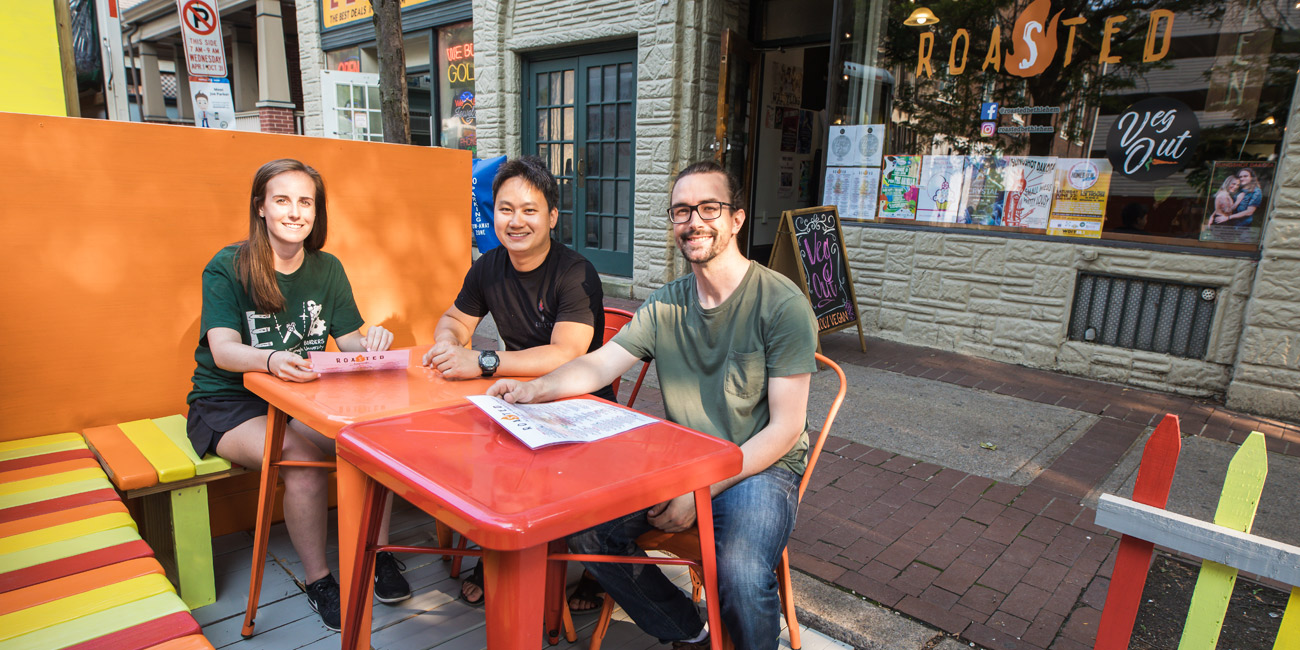Three people eating outside at a restaurant