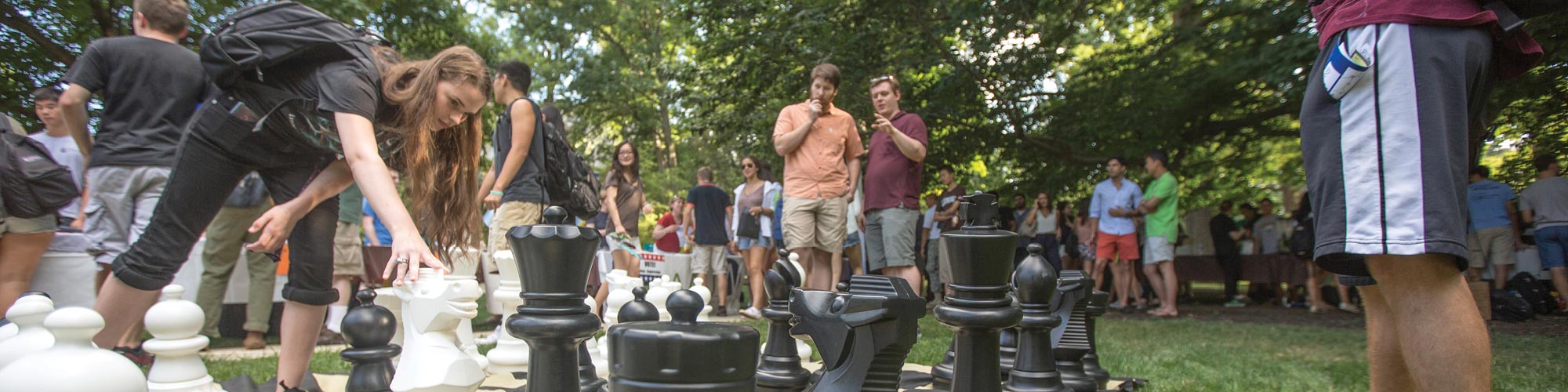 Student moving a giant chess piece