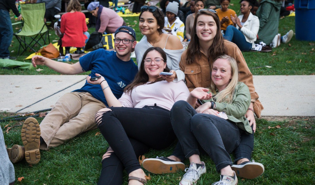 Group of Lehigh students sit on lawn at Brown & White BBQ. 