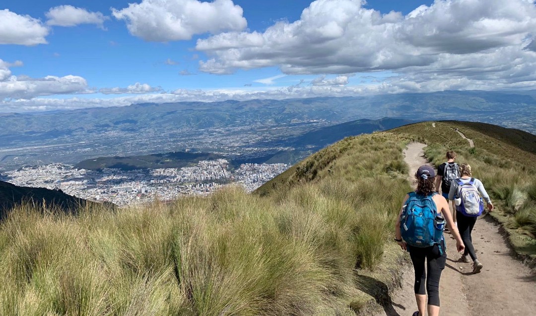 Students hiking on mountain near Quito, Ecuador with a view of the city below. 