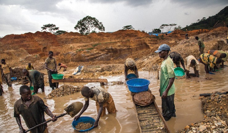 Workers dig for conflict minerals in muddy river in Congo. 