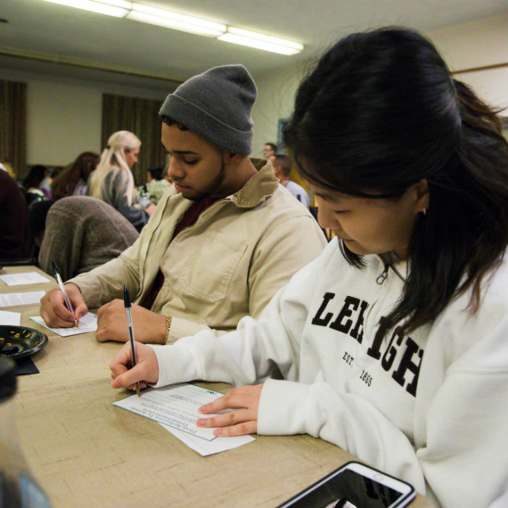 Lehigh students writing on cards