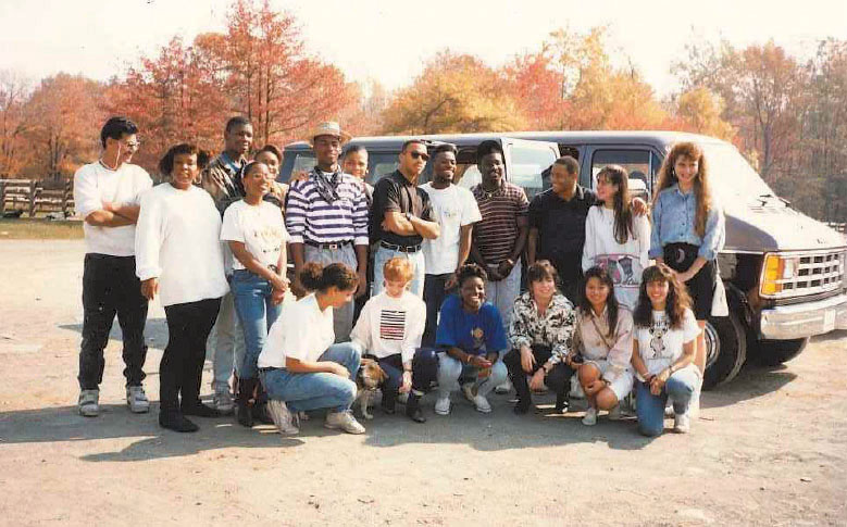 Group of people posing near a van
