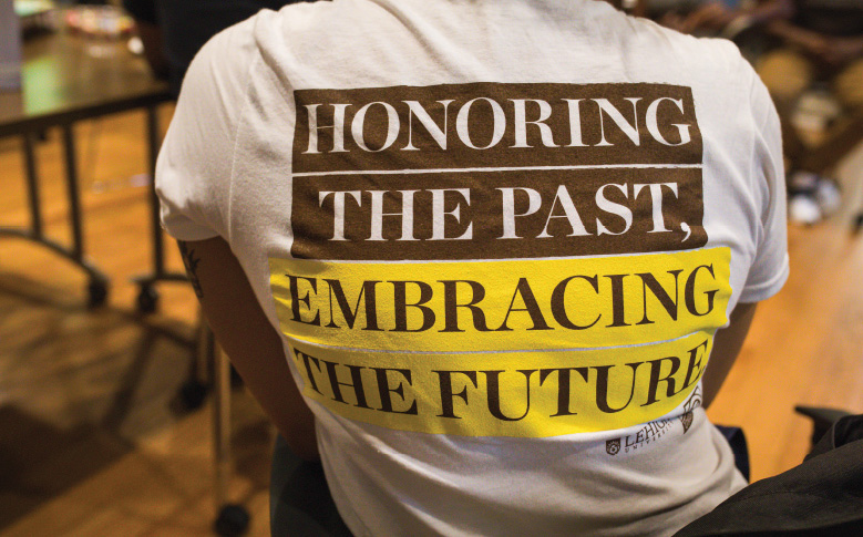 Back of a t-shirt reading, 'Honoring the past, embracing the future'