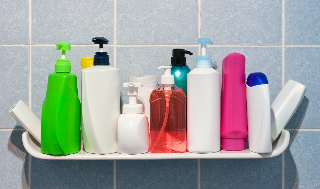 A collection of colorful shampoo bottles on a shower shelf