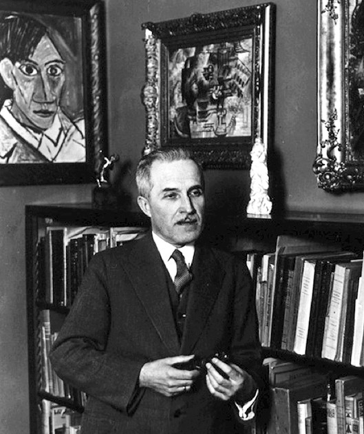 Vincenc Kramář at his home in Prague, standing in front of Picasso paintings