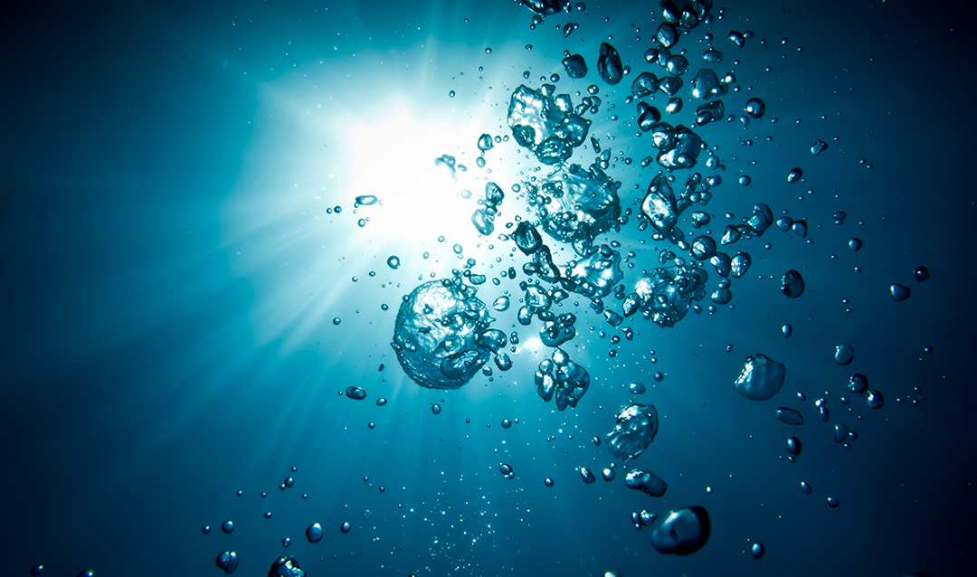 image of bubbles in water with sunlight shining down
