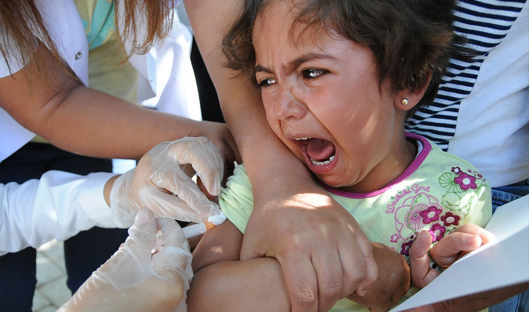 Young girl crying while receiving a vaccine