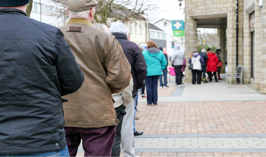 people standing in line to get into a pharmacy