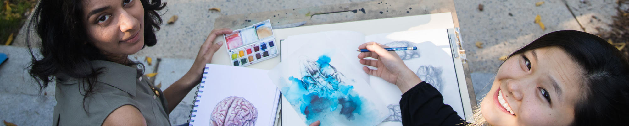  Sarrah Hussain '21 and Viola Yu '21 show medical illustrations they created.