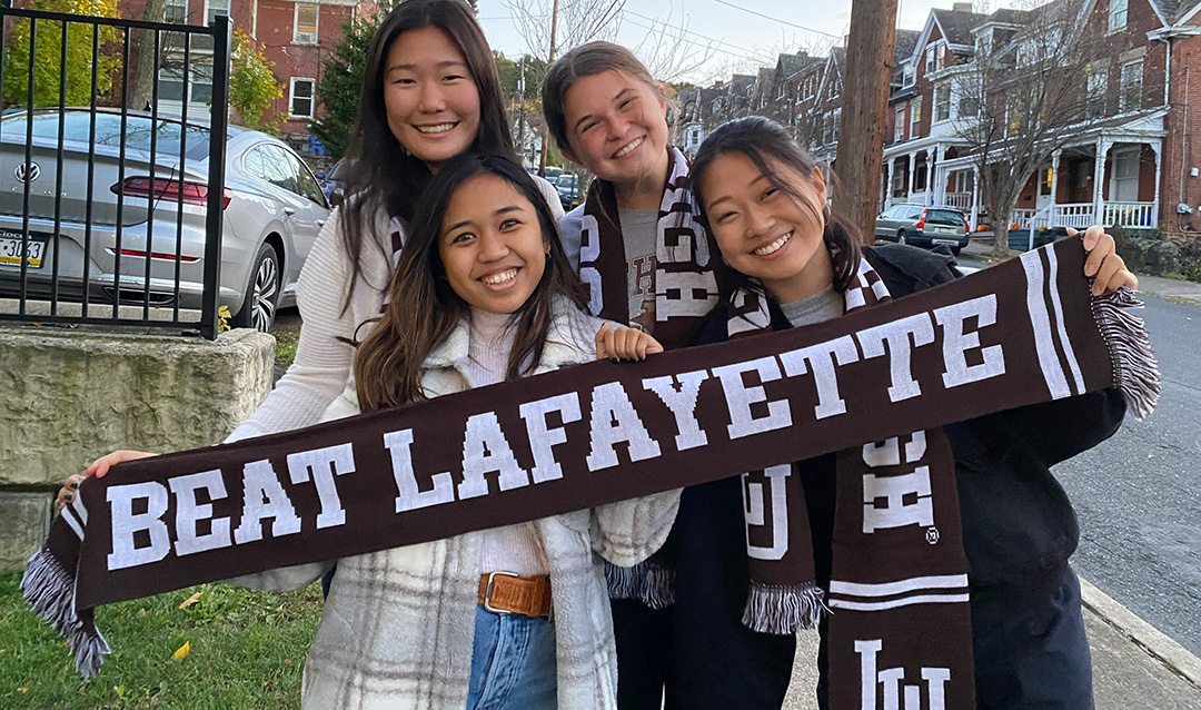 Students holding a "Beat Lafayette" scarf