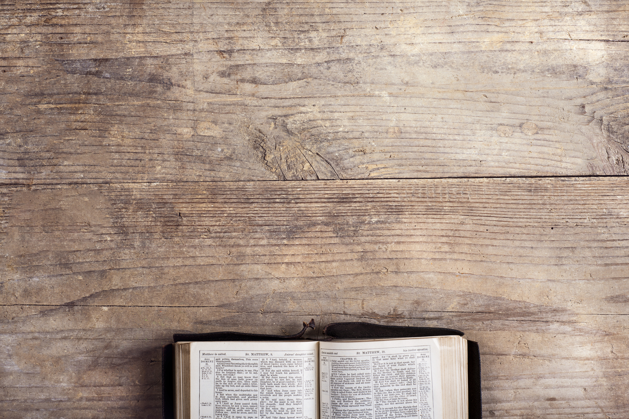 a bible open on a wooden desk