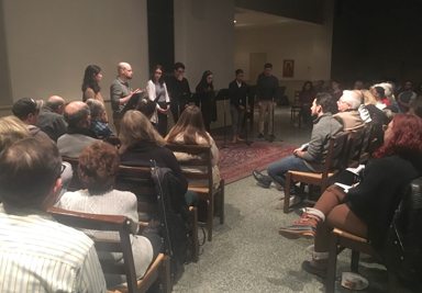 A room of people watching a panel speaking