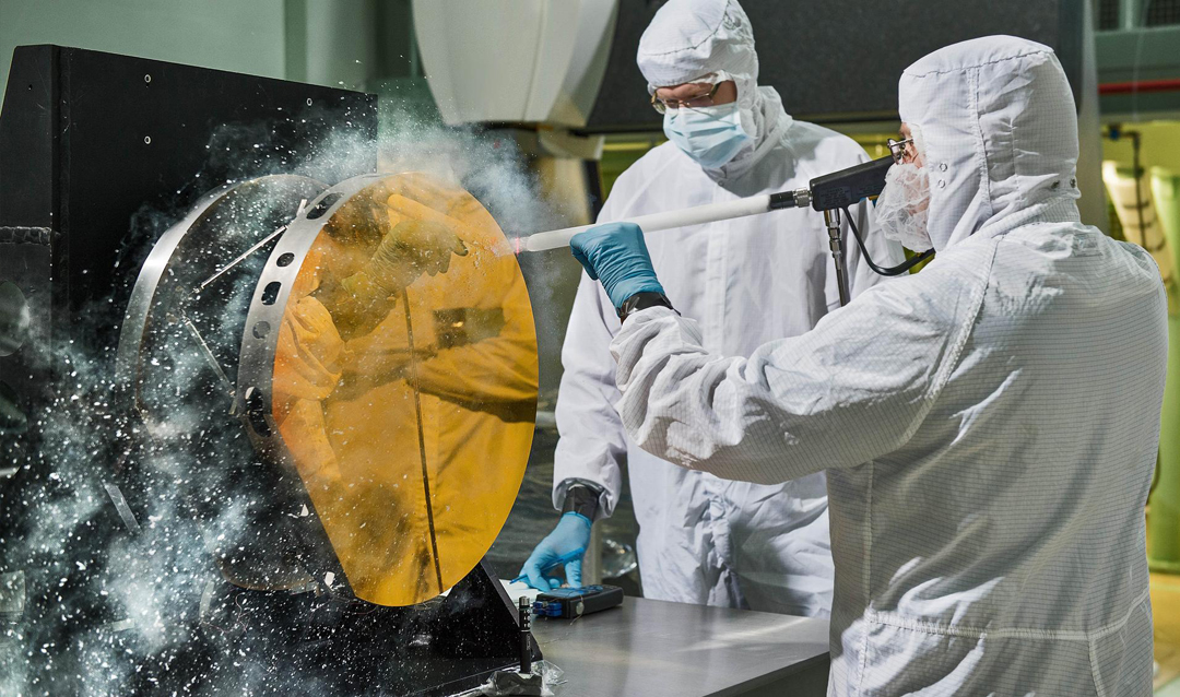 Engineers clean a mirror of the James Webb Space Telescope