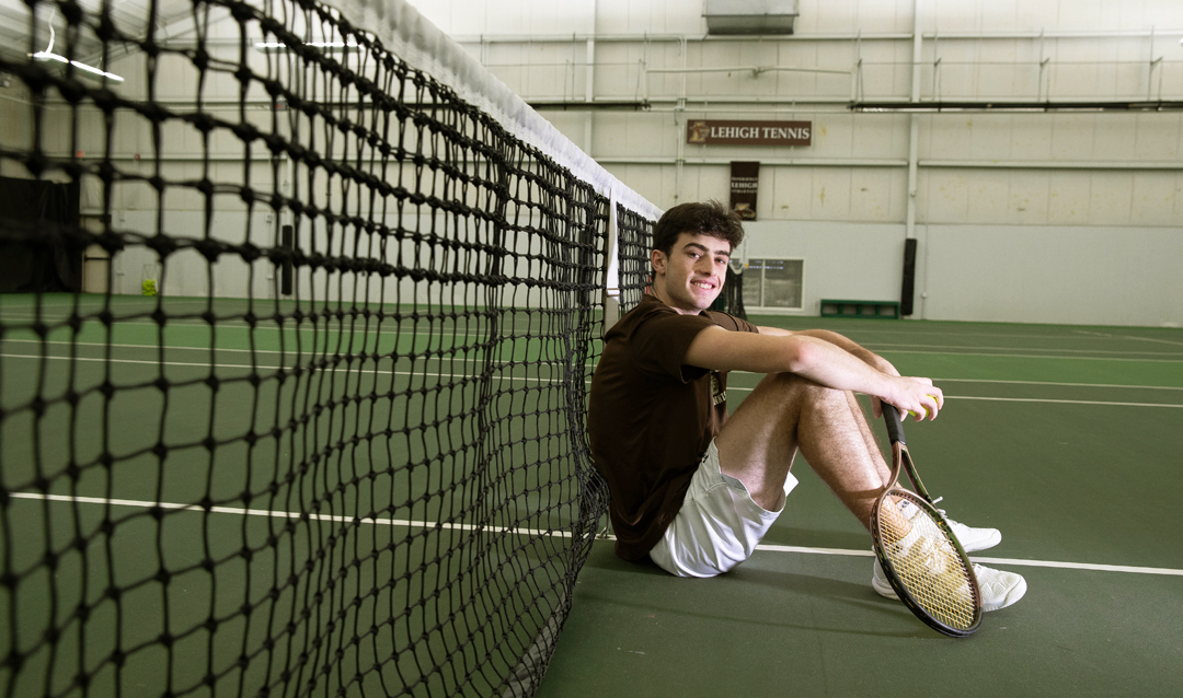 Marc Blekhman sitting at tennis net