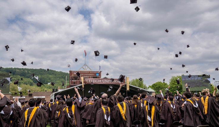 students toss mortar boards in air