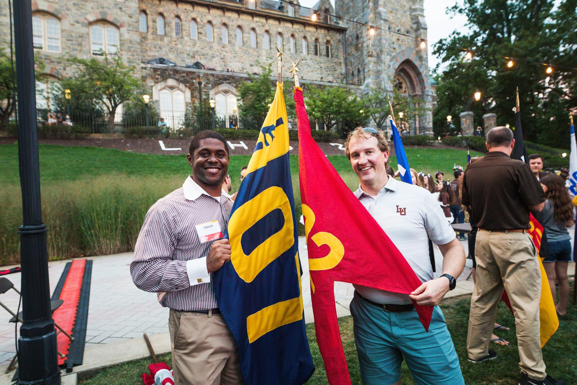 To students holding up flags outside of an academic building