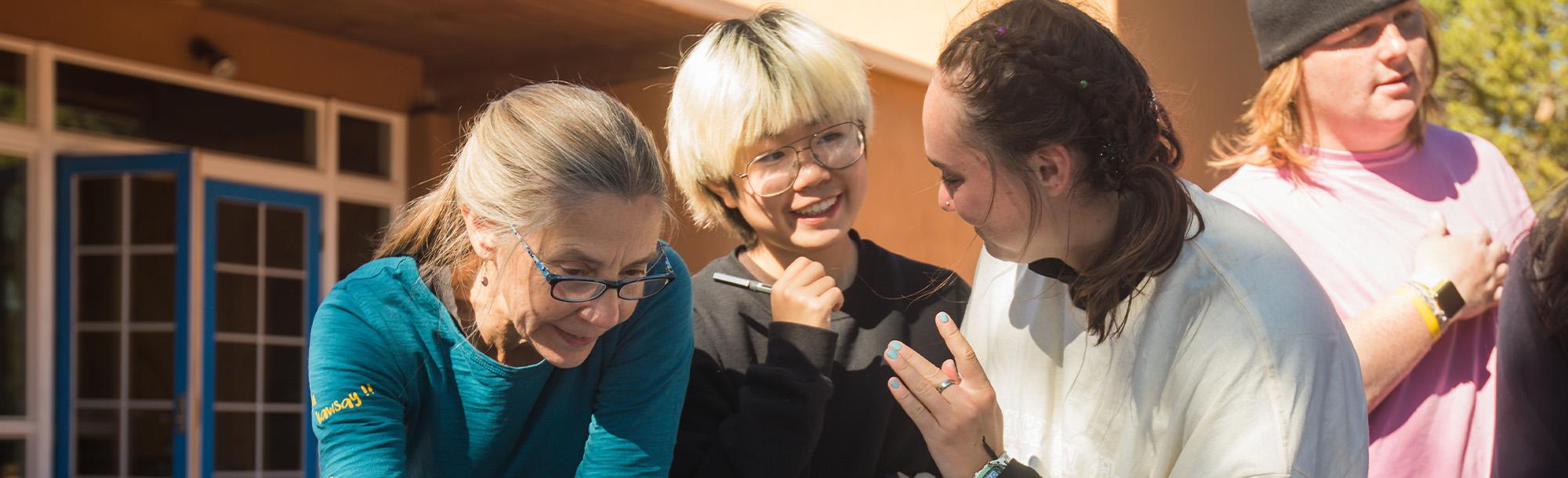 Two students talking next to a female faculty member