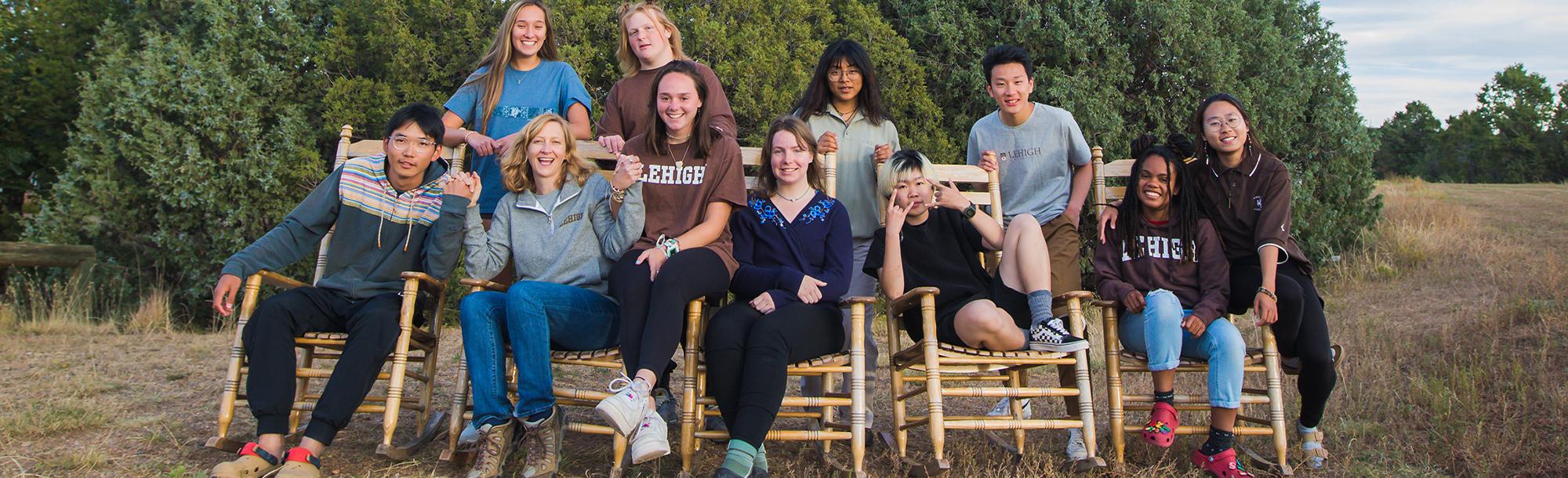 Group of students standing and sitting in rocking chairs