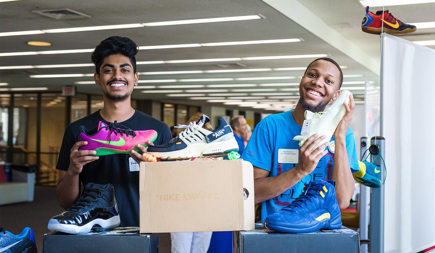 Two young men holding sneakers