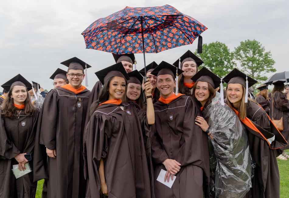 graduates pose in the rain