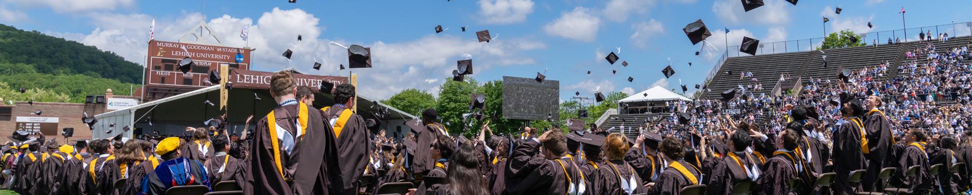 students toss mortarboards