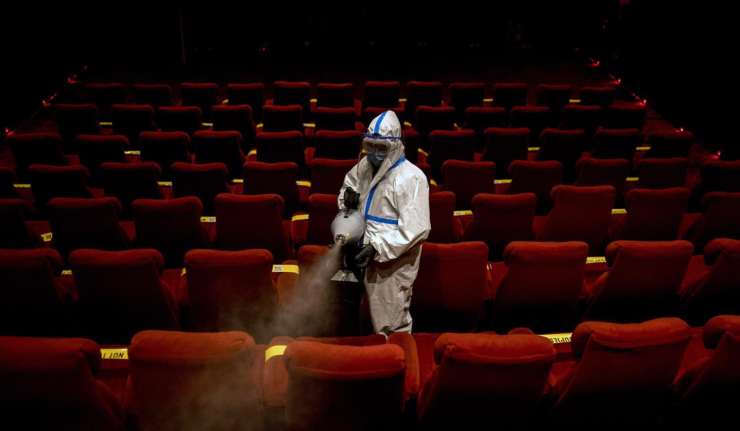 A worker sanitizes a theater