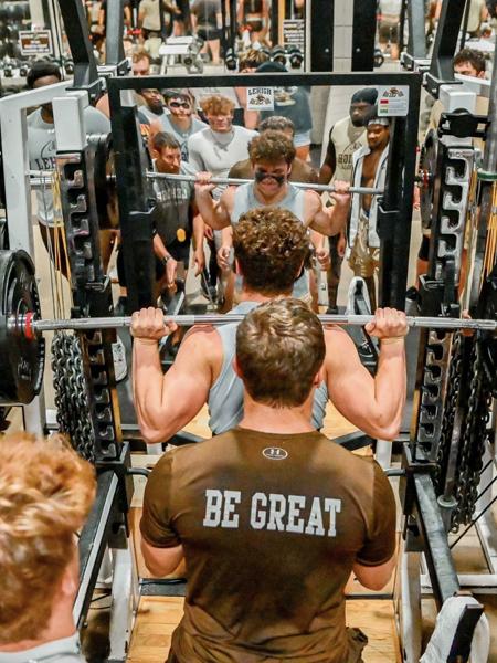 Football players lifting weights