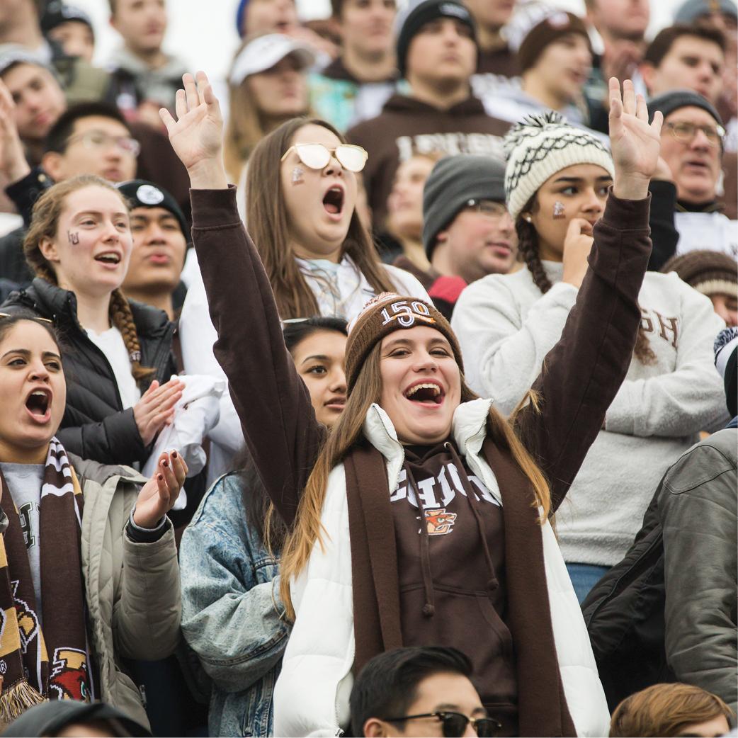 A group of student cheering in the stands at a football game