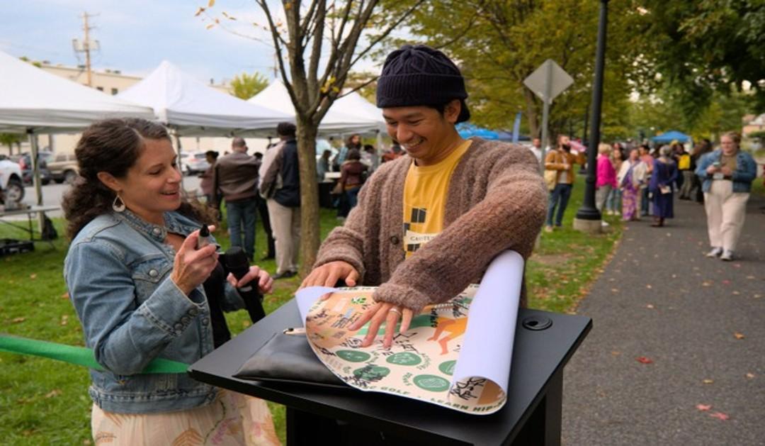 two people smiling working on art project outside 