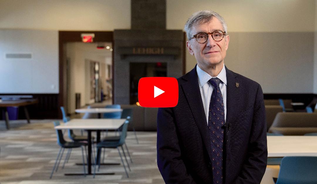 President Helble stands in front of fireplace in Clayton UC