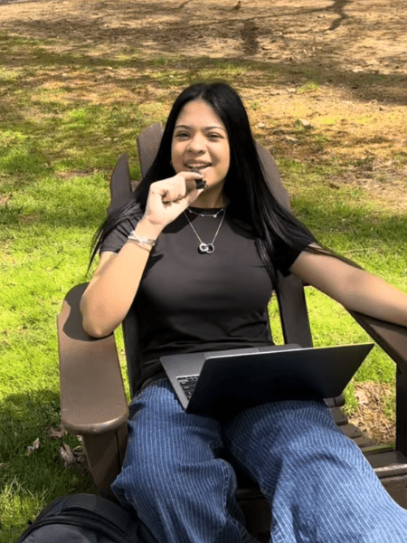 Student seated outside with laptop