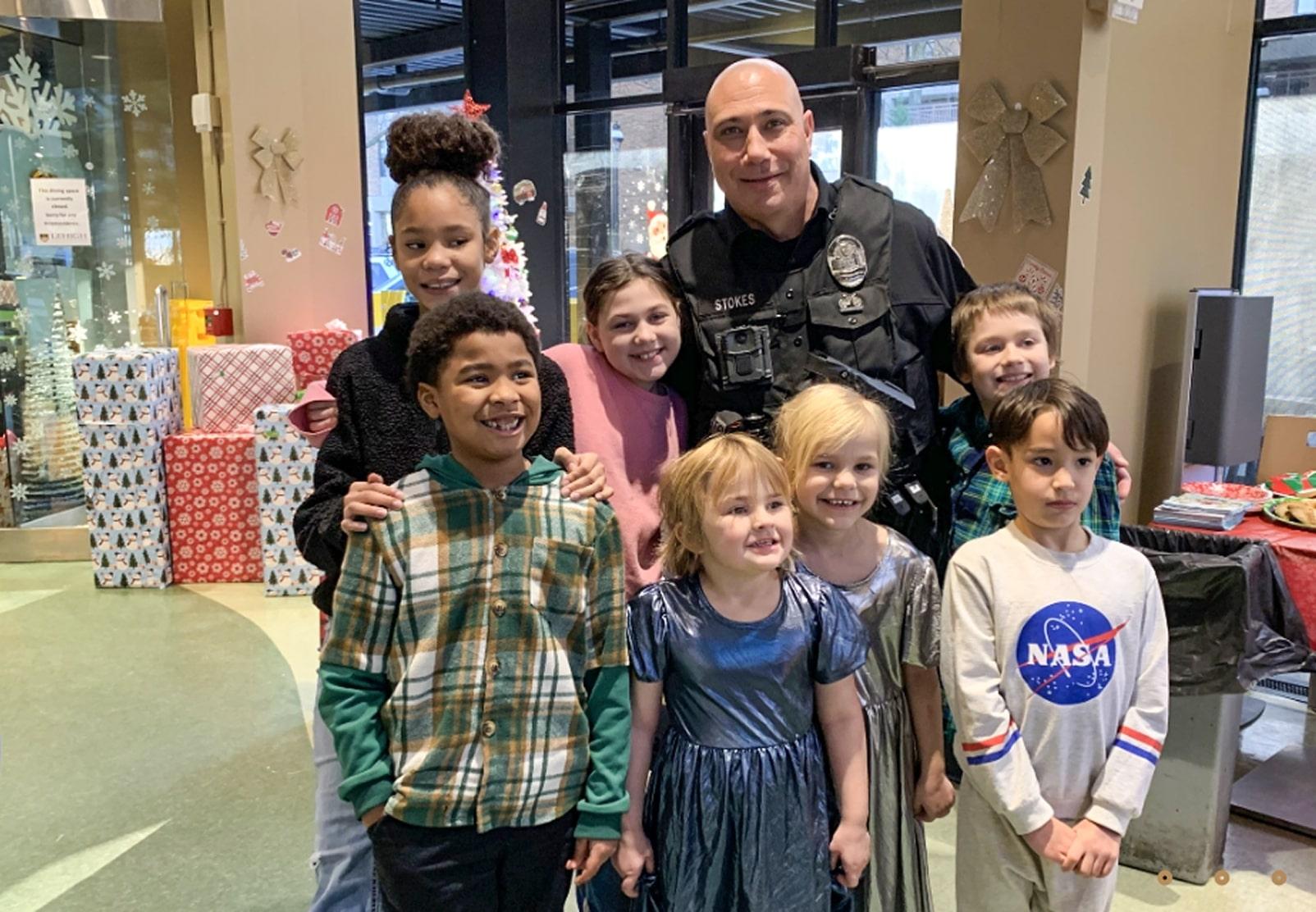 Woman, police officer, and small children posing in a shop
