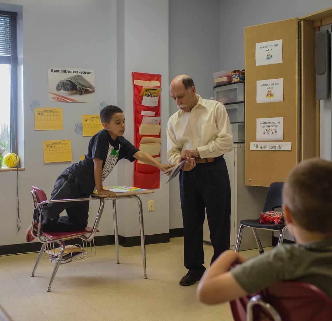Professor leading a class next to a student at a desk