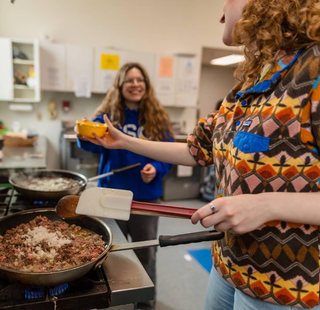 Two volunteers cooking