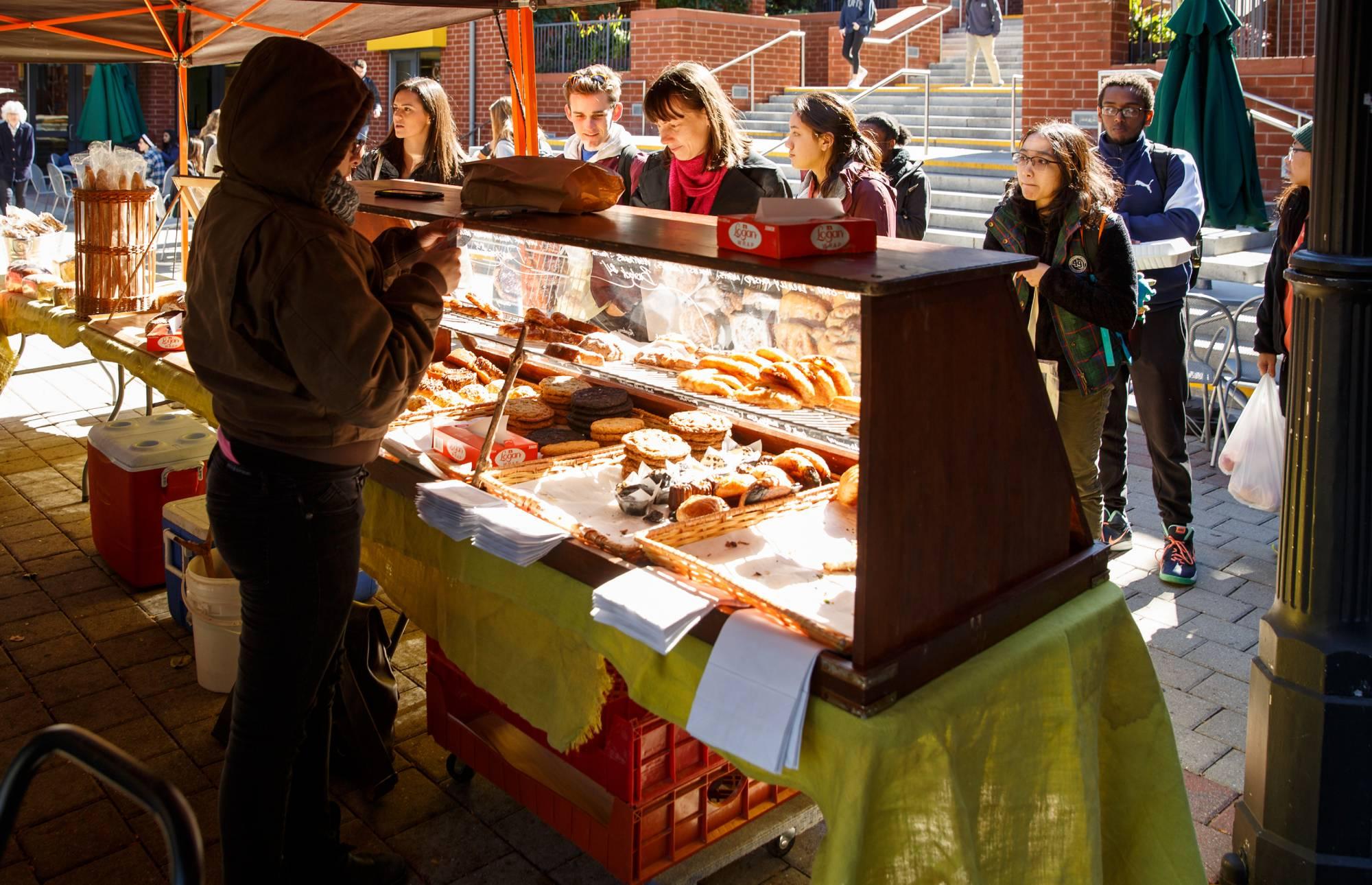 Customers lining up at the counter of a farmers' market vendor
