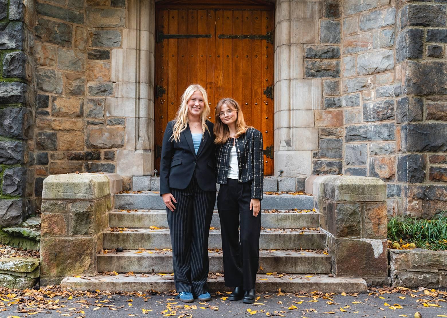 Two female officials standing in front of a doorway