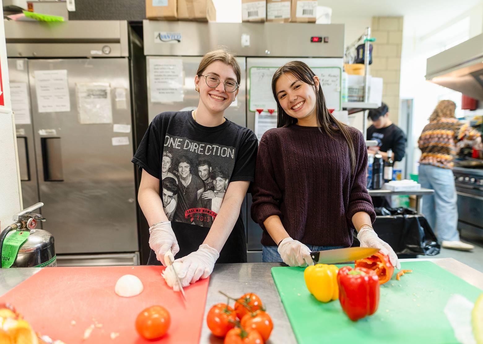 Two volunteers posing in a kitchen