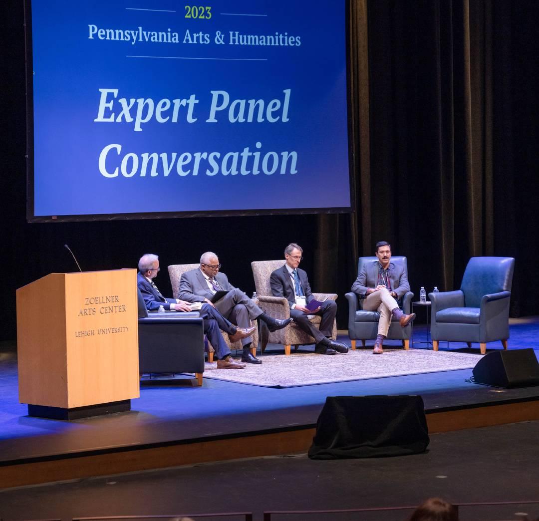 Three people sitting on a stage during a panel discussion