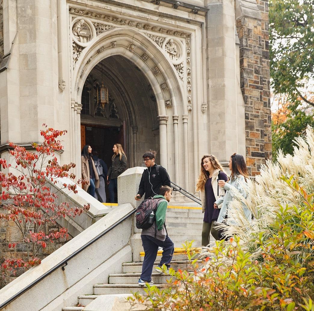 Exterior of a building with students walking down stairs