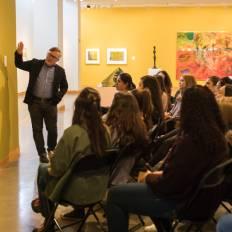 A professor showing off pieces in an art gallery