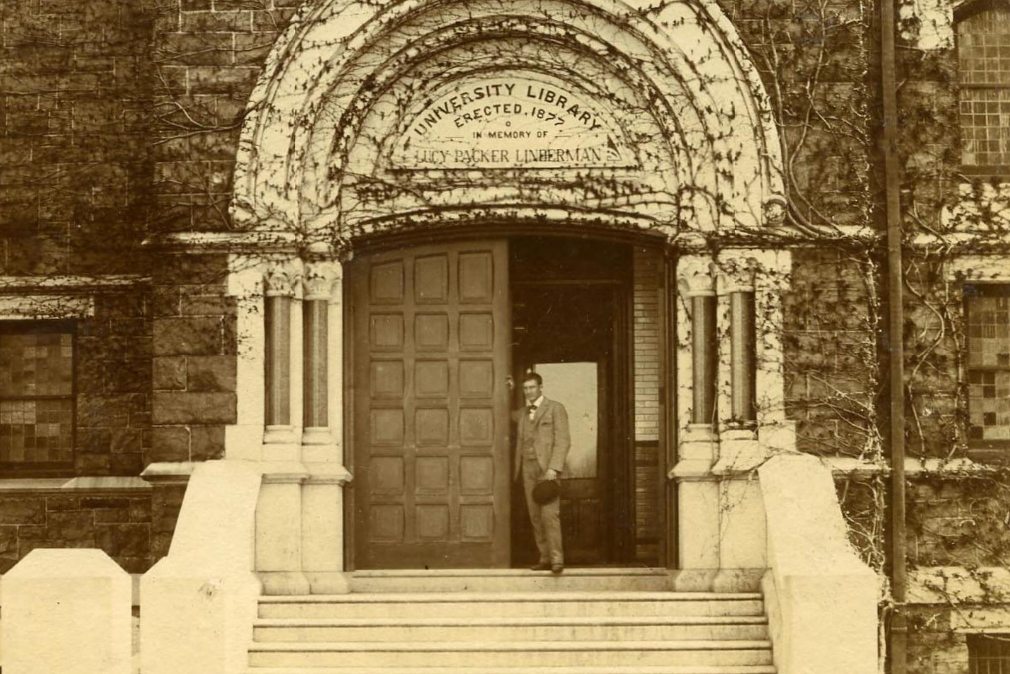 Old photo of someone standing in the doorway of an academic building