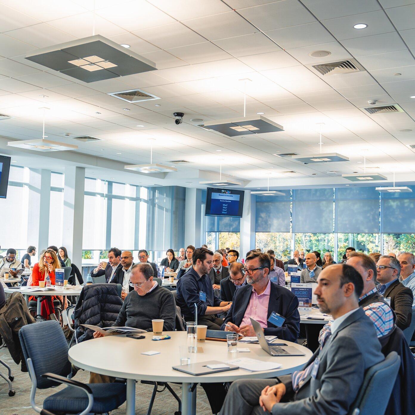 People sitting in a crowded conference room