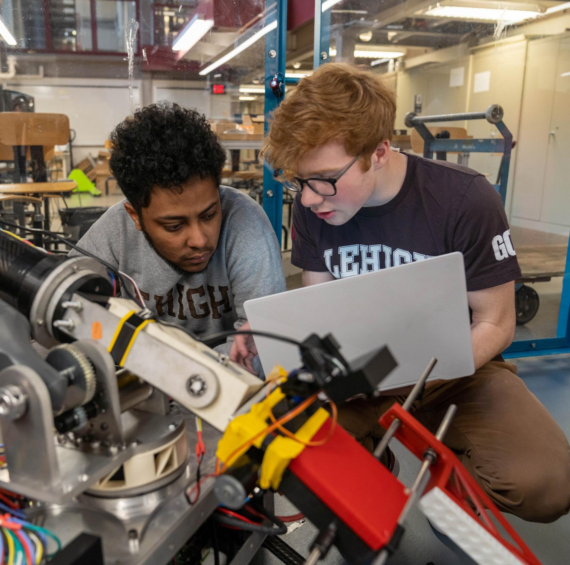 Two students working on a machine